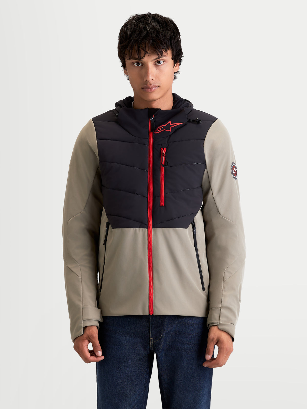 Alpinestars Therma-Tech WP Chaqueta, chaqueta de moto urbana contemporánea para hombre, en negro y vetiver, vista frontal en un modelo que lleva la chaqueta textil con capucha y cremalleras rojas