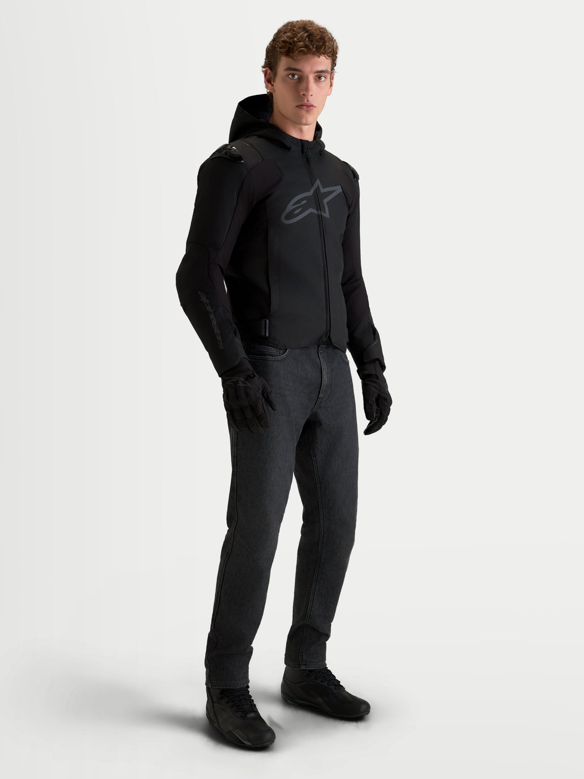 Alpinestars Zaca V2 Waterproof Chaqueta, chaqueta de moto de tejido negra con capucha para hombre, con certificación CE AA y movilidad de softshell elástico, vestida por un modelo