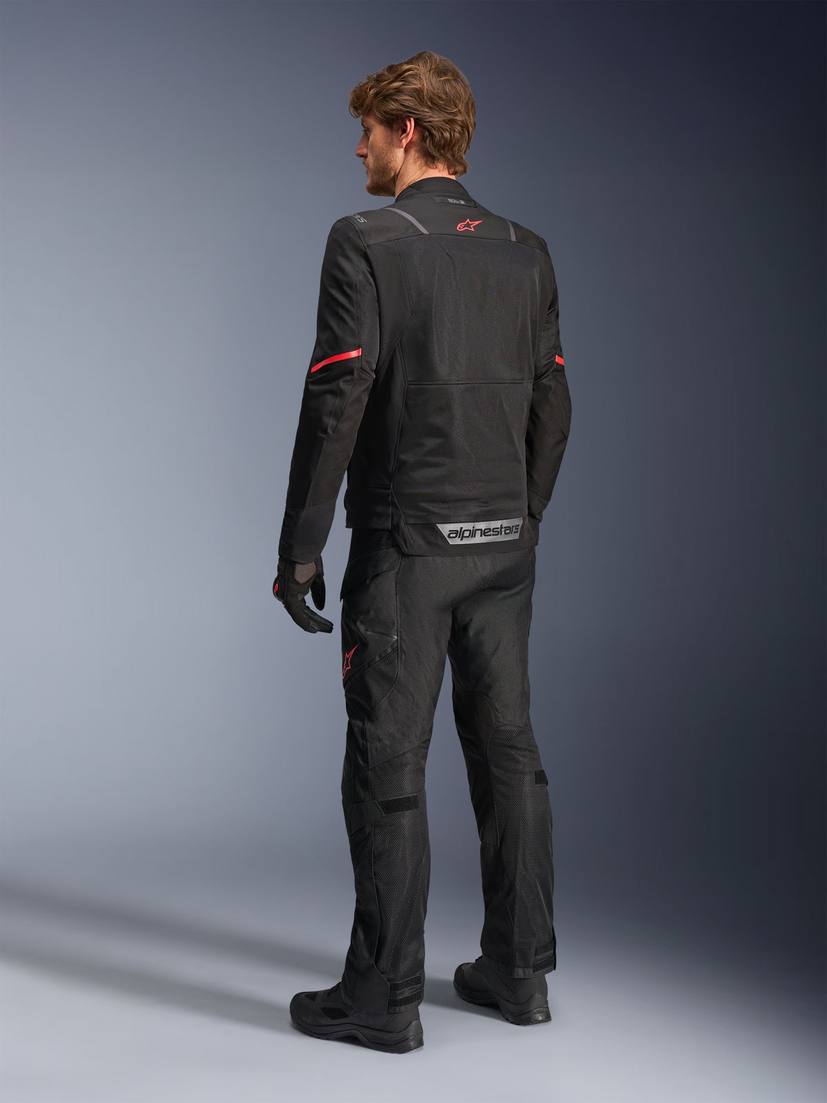 Alpinestars ST-2 Air, chaqueta de moto adventure touring de hombre, negra y roja con paneles de malla, vista posterior.