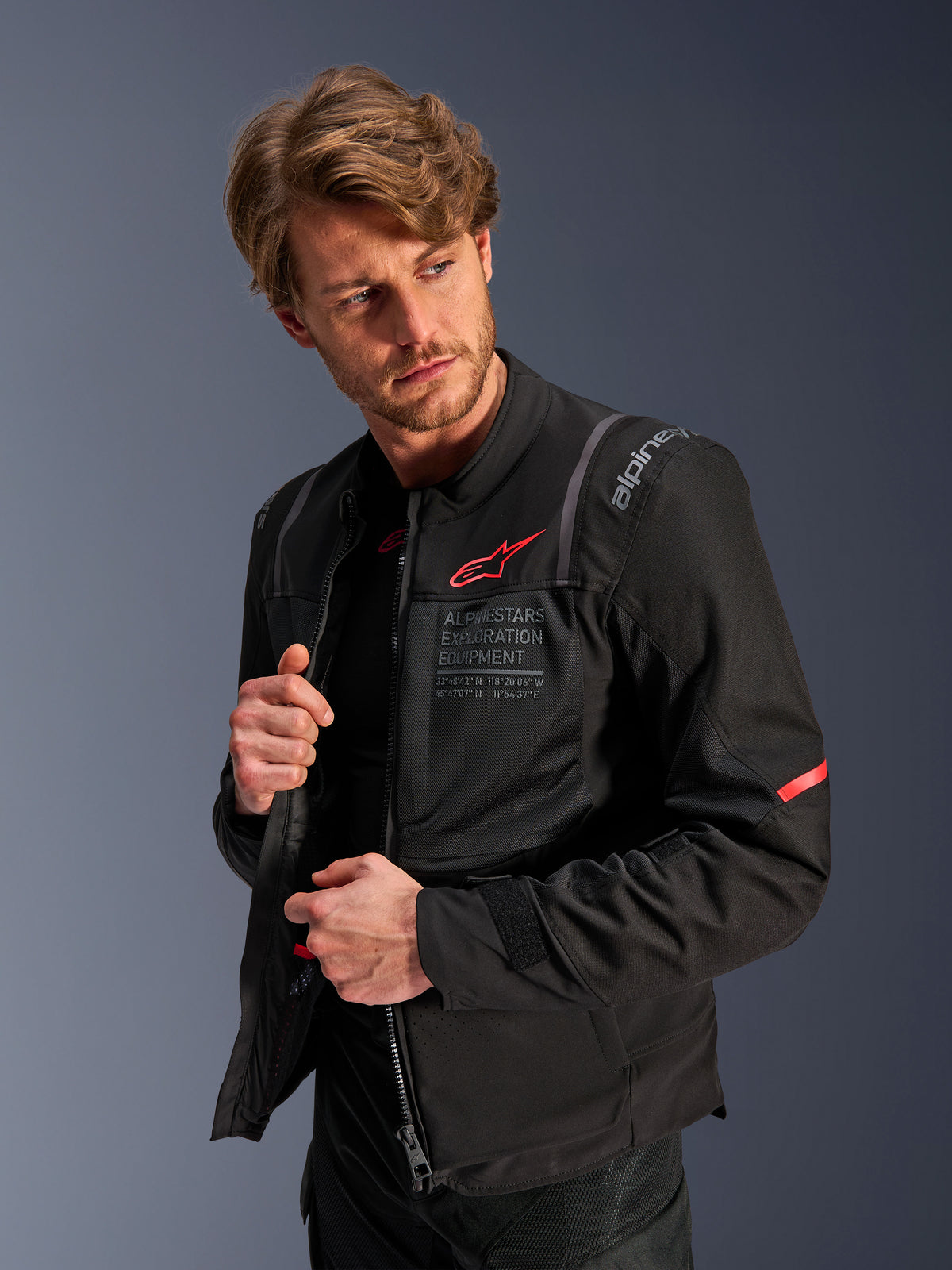 Chaqueta Alpinestars ST-2 Air, chaqueta de moto touring negra para hombre con malla y logo rojo, usada por un modelo.