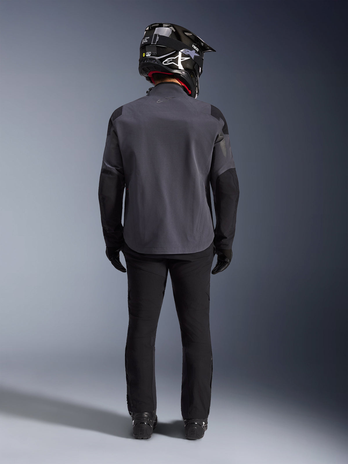 Alpinestars Maxdura Drystar®XF Laminated Armored Shell, color Deep Gray Black, vista trasera completa, chaqueta técnica de aventura con paneles reforzados, combinada con pantalones de montar negros, guantes y casco off-road en blanco y negro, conjunto de equipamiento dual-sport coordinado
