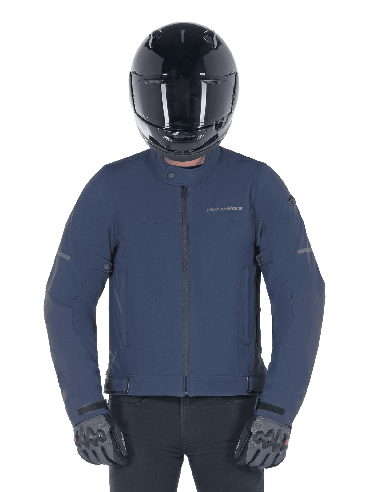 Chaqueta Alpinestars Husker Waterproof, azul Night Navy, chaqueta urbana para motociclista combinada con un casco integral negro y guantes grises, con exterior de softshell técnico y logotipos discretos