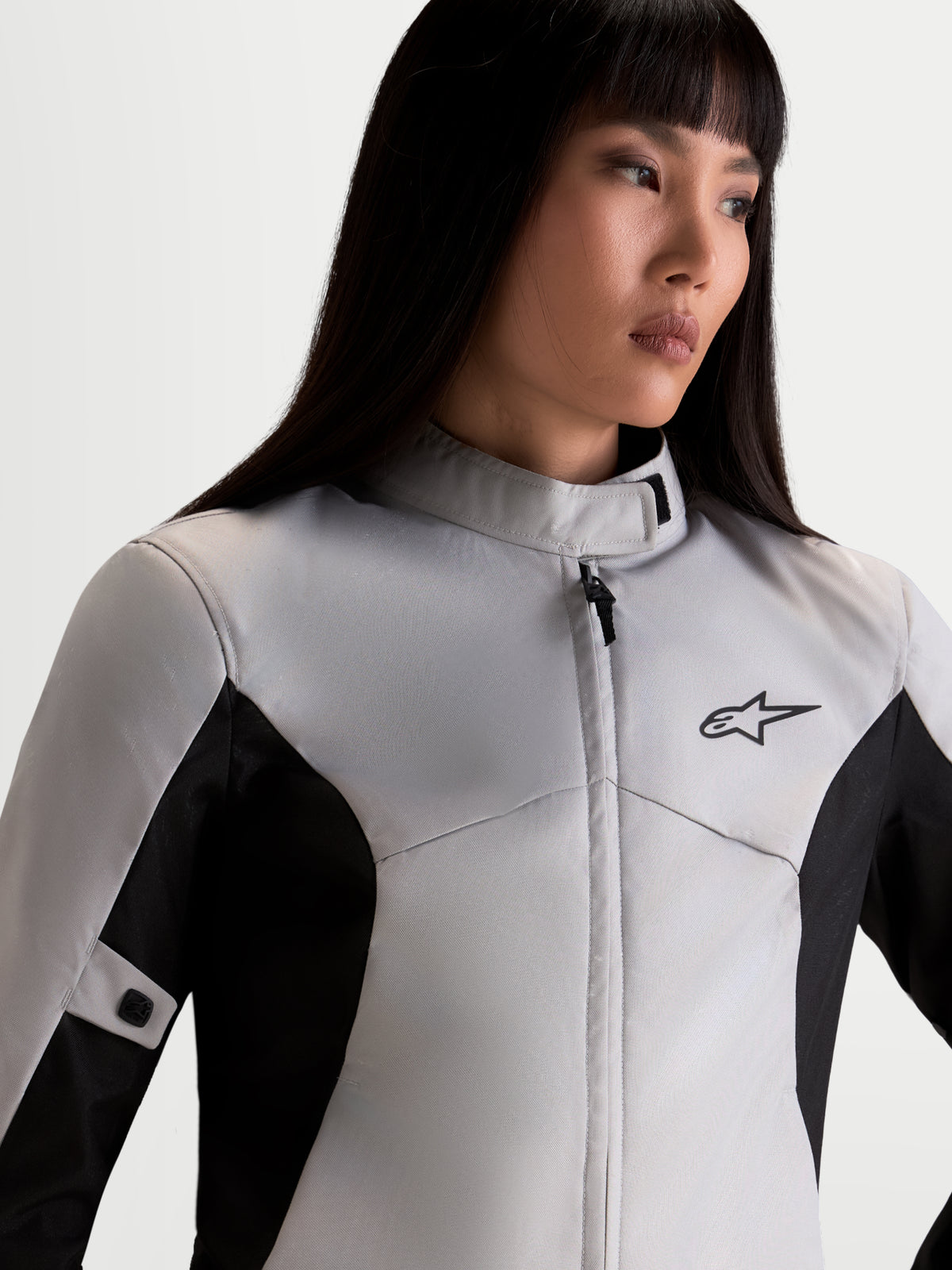 Alpinestars Stella C-1 Waterproof Chaqueta, chaqueta de moto urbana para mujer en gris hielo y negro, vista de la parte superior del cuerpo en primer plano mostrando el cuello alto, construcción textil impermeable y logotipo A-star en modelo