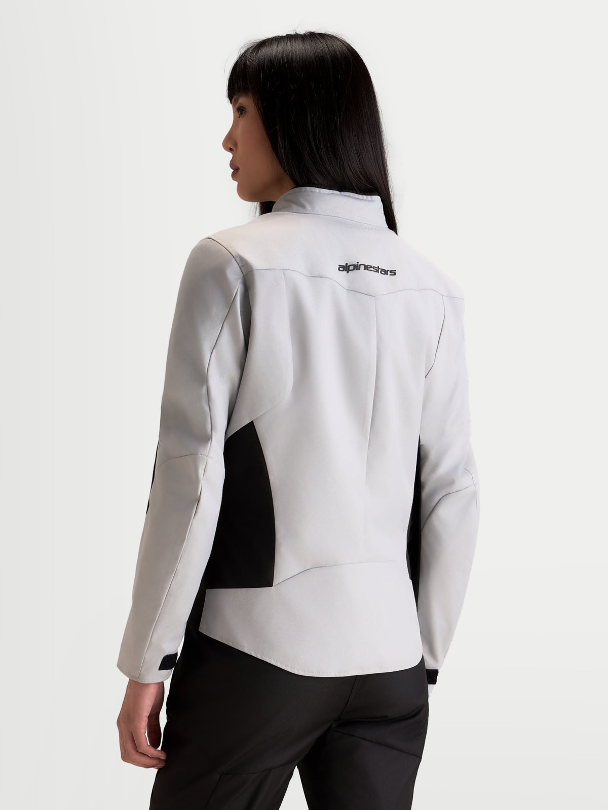 Alpinestars Stella C-1 Waterproof Chaqueta de moto urbana para mujer, gris hielo y negro, vista trasera en modelo mostrando la construcción 3D de la espalda y el logotipo de la marca