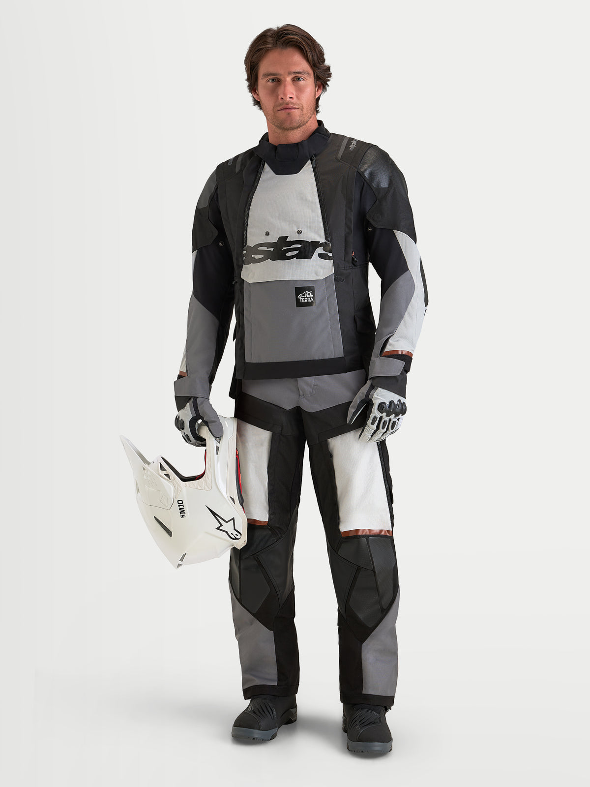 Alpinestars Harok V 2 Drystar Pantalones de moto de aventura, gris oscuro, gris hielo y negro, modelo con chaqueta ADV y casco blanco, equipamiento todoterreno certificado CE