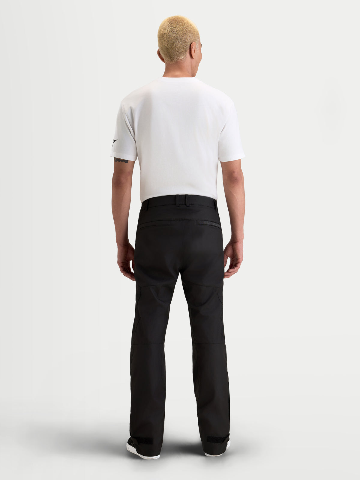 Alpinestars C-1 Waterproof Pantalones, pantalones de moto urbanos contemporáneos para hombre en negro, vista trasera en modelo con camiseta blanca y equipo textil impermeable