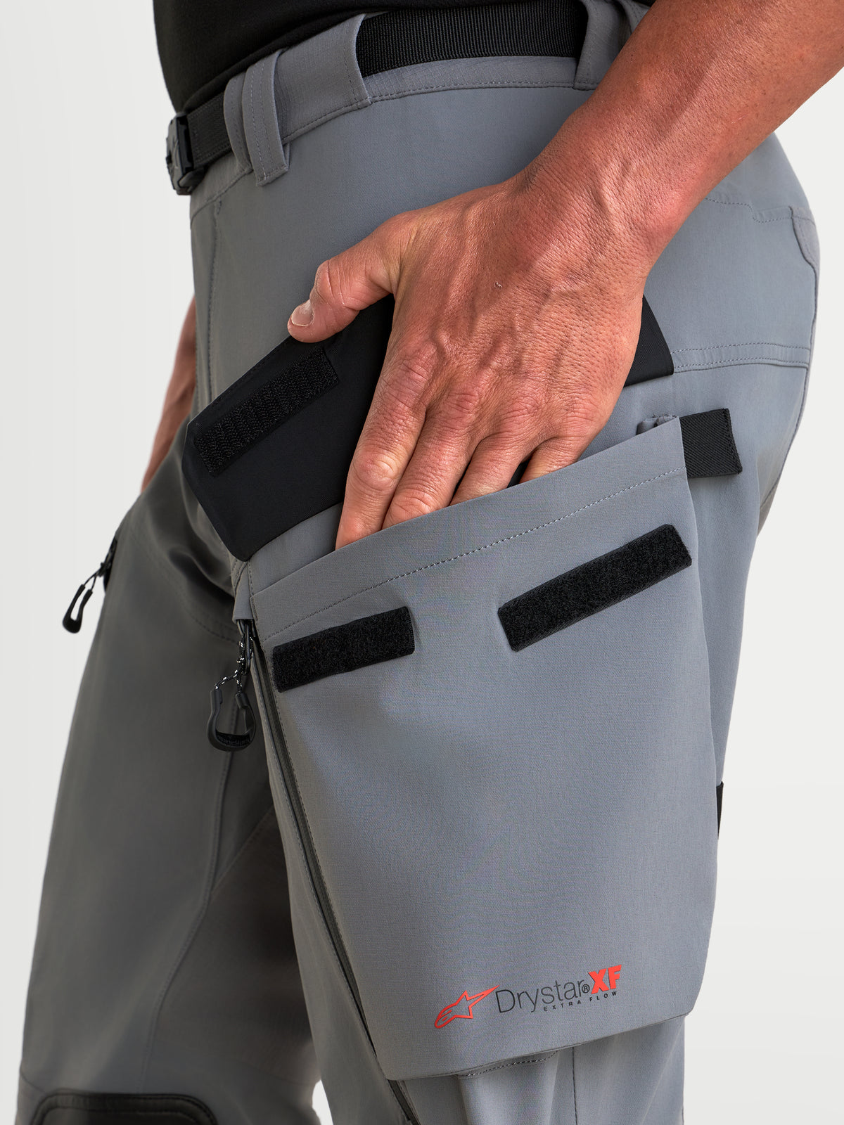 Alpinestars Maxdura Drystar XF Laminated Pantalones, pantalones de moto adventure, gris oscuro y negro, con bolsillo cargo angulado en el muslo y detalle de branding Drystar XF en primer plano