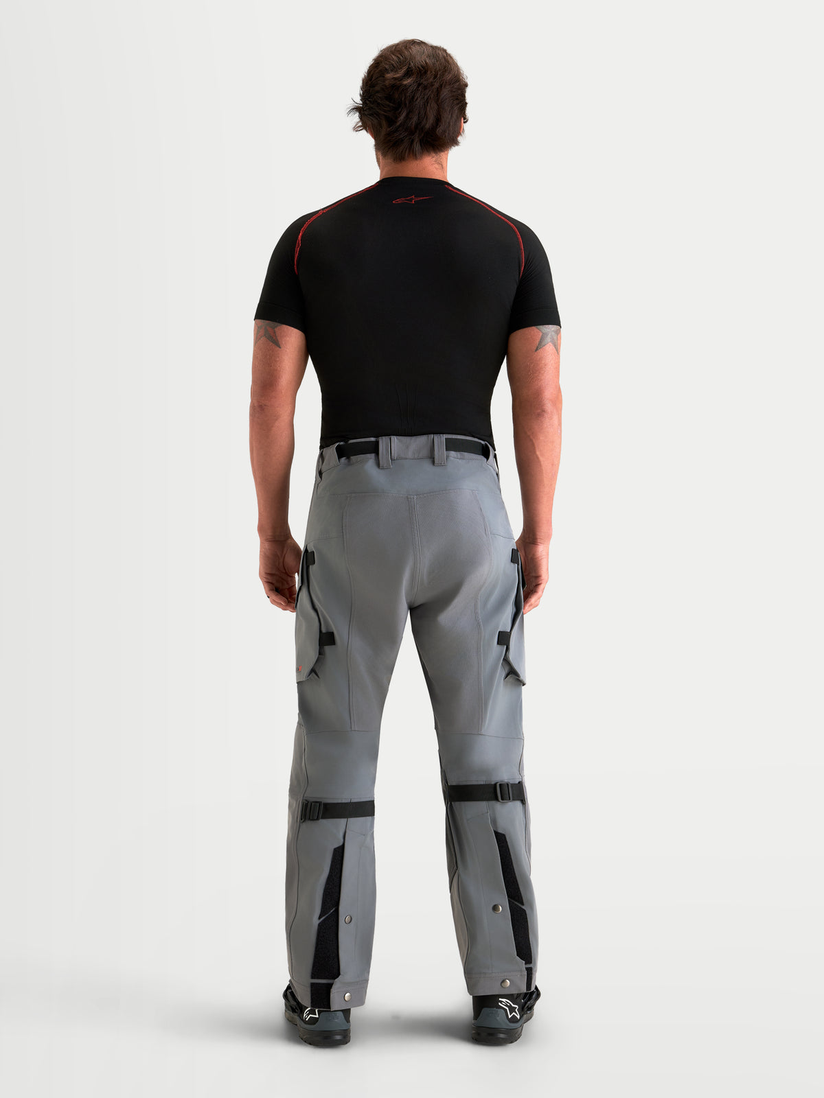 Alpinestars Maxdura Drystar XF Pantalones, pantalones de moto adventure para hombre, gris oscuro, vista trasera en modelo mostrando la construcción textil impermeable, cinturón integrado y piernas ajustables