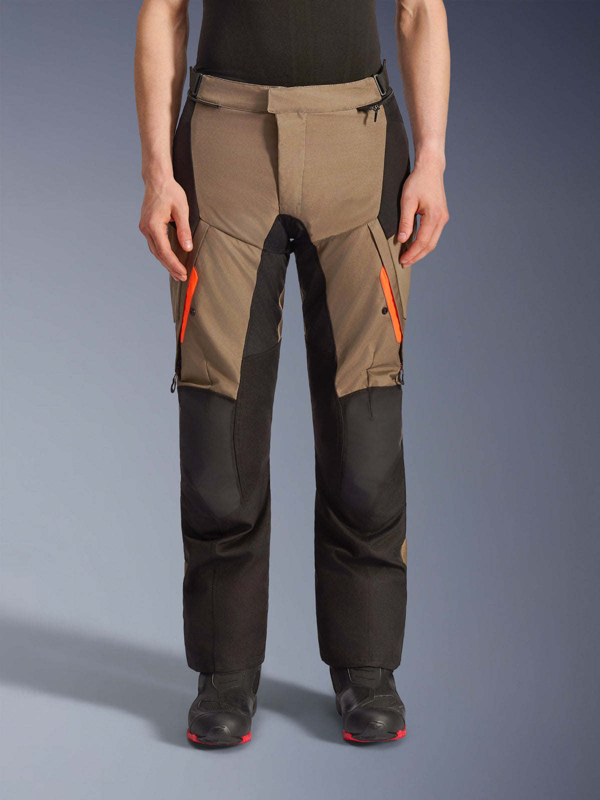 Alpinestars Andes V4 Drystar® Pants, pantalones de moto para turismo y aventura en marrón y negro, con cremalleras naranja brillante en los muslos, paneles de rodilla negros reforzados y construcción textil duradera para conducción en cualquier clima