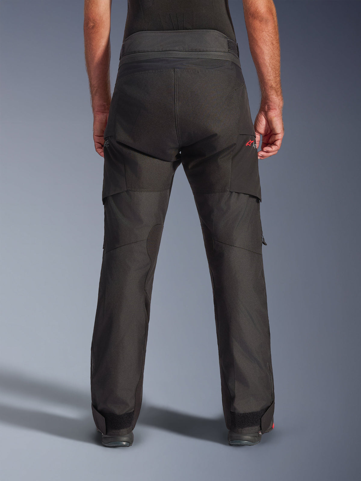 Pantalones Alpinestars Andes V4 Drystar®, pantalones de moto de aventura, negros, vista trasera con paneles reforzados en el asiento y la parte inferior de las piernas, confección textil de cintura alta con correas ajustables en cintura y tobillos