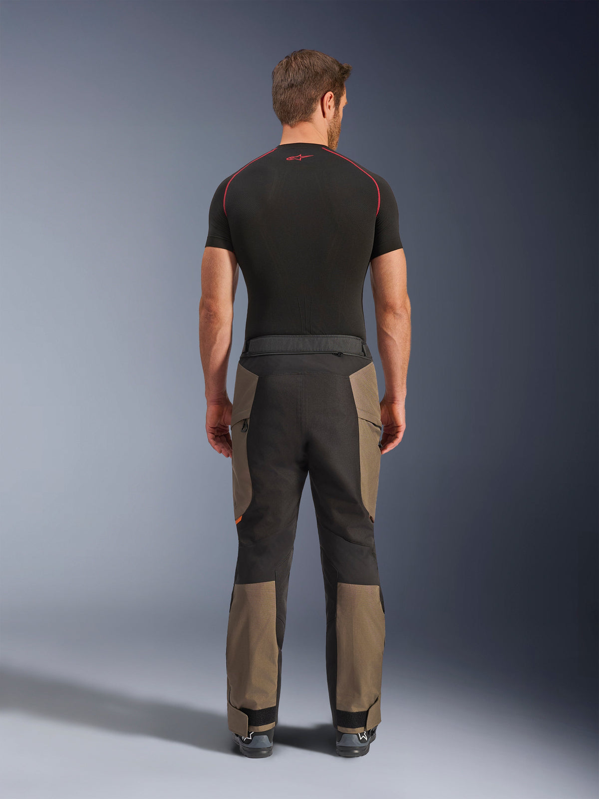 Alpinestars Cusco Drystar® Pants, pantalones de motociclismo adventure, Walnut Black, vista posterior con paneles marrones y negros, construcción de tejido ripstop duradero, usados con una camiseta de capa base negra
