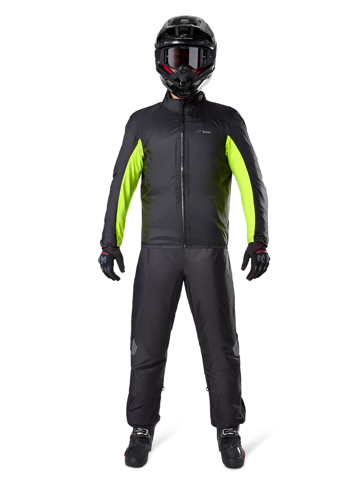 Pantalones Alpinestars Bogota Pro Drystar 3 Seasons, negros, usados por un motociclista con un conjunto completo de aventura que incluye una chaqueta impermeable negra y amarillo neón, casco negro y botas de conducción, diseñados para un alto rendimiento de touring en cualquier clima.