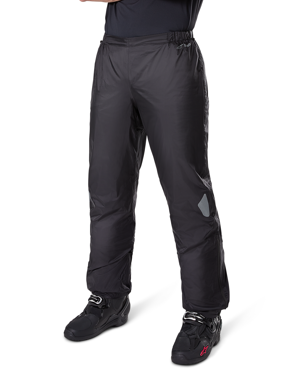 Pantalones Alpinestars Bogotá Pro Drystar® 3 Seasons, pantalones de moto para aventura y touring, color negro, usados con botas de moto negras, con parches reflectantes en las rodillas y logotipo Drystar, diseño textil impermeable y ligero para conducción multiestación