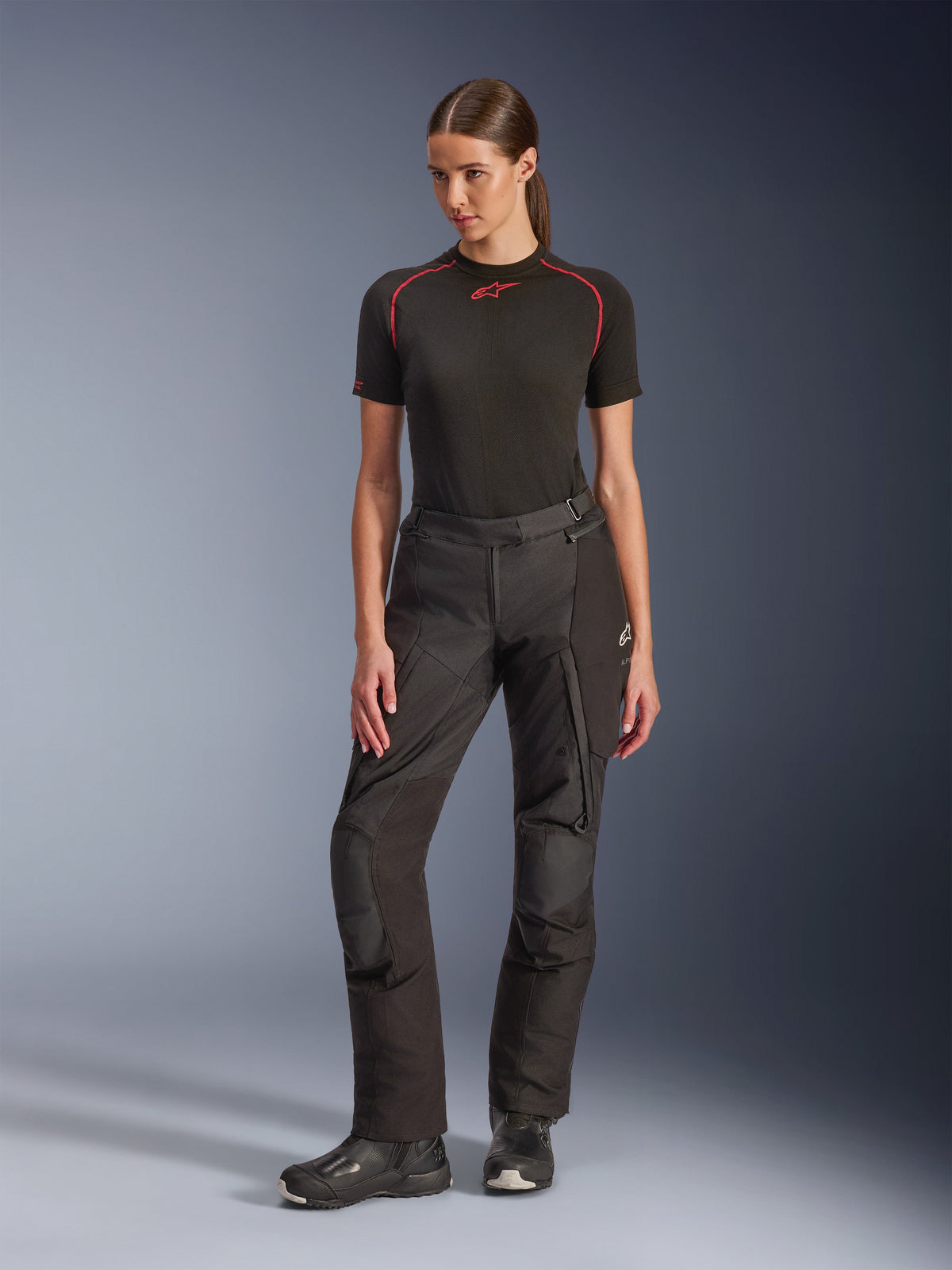 Alpinestars Stella Andes V4 Drystar® Pants, Women's Adventure Motorcycle Pants, Black, worn by a model with a black short-sleeved base layer and black riding boots, featuring reinforced knees and cargo pockets, ergonomic design for all-weather touring.