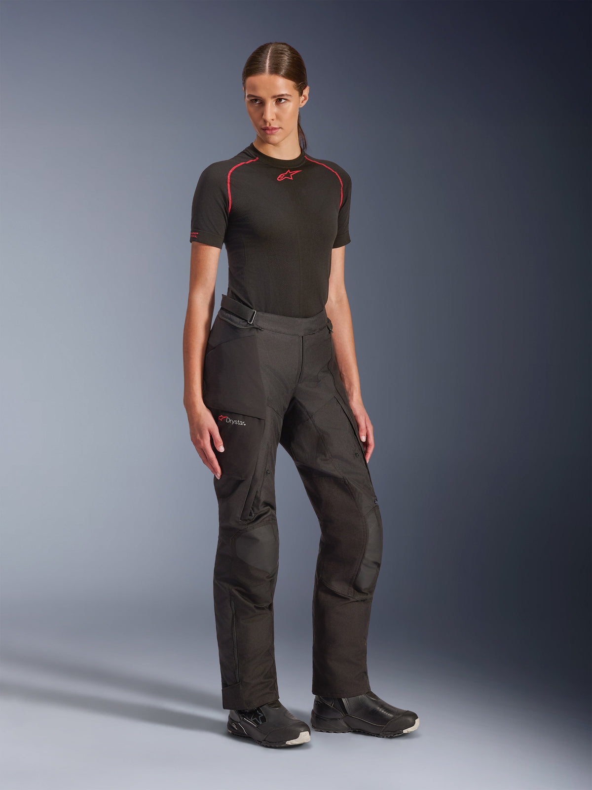 Alpinestars Stella Andes V4 Drystar® Pants, Black, adventure touring motorcycle pants for women, worn with a black short-sleeve base layer and black riding boots, featuring waterproof Drystar technology and cargo pockets