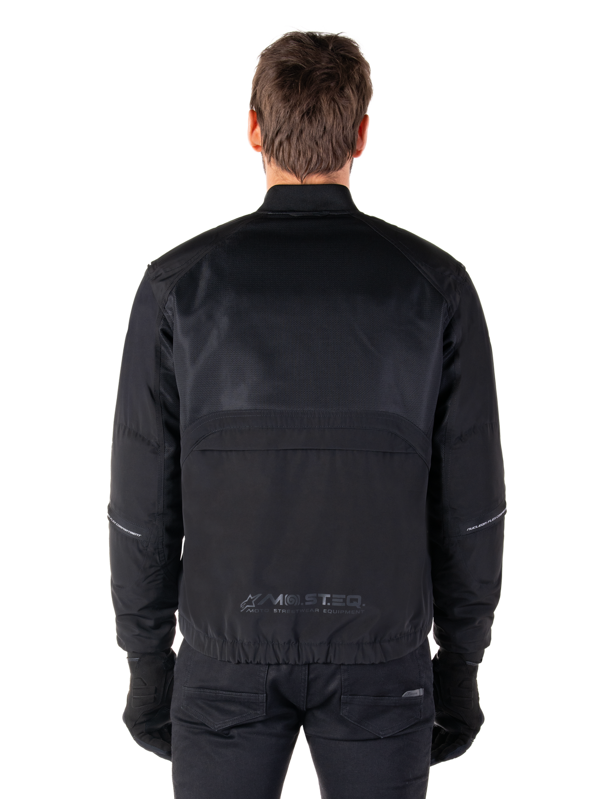 Alpinestars Mootant Waterproof Parka, chaqueta de moto negra, vista trasera que muestra la malla superior para el flujo de aire y el logotipo reflectante MO.ST.EQ. en la parte inferior de la espalda, equipamiento modular para las 4 estaciones