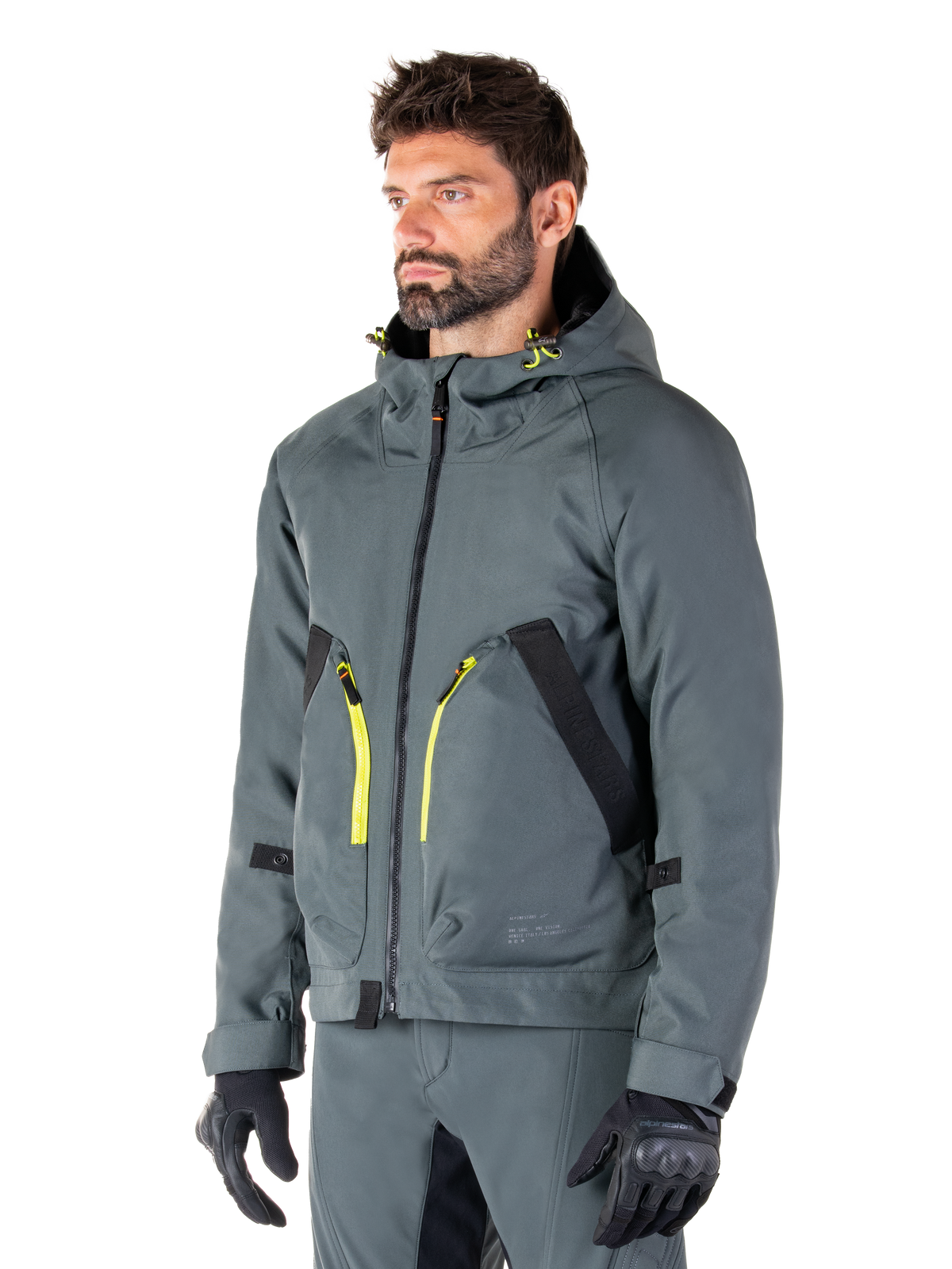 Alpinestars Morush Waterproof Parka, Urban Gray motorcycle jacket, hooded design with bright yellow zipper accents, black pocket detailing, worn with matching gray riding pants and black gloves, contemporary streetwear-inspired motorcycle apparel.
