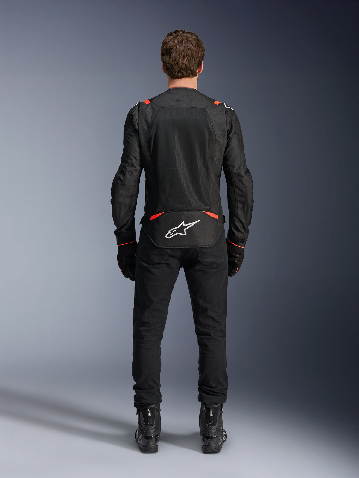 Chaqueta Alpinestars T-SPS Air V2 para hombre, negra y roja flúor, vista trasera con paneles de malla textil.