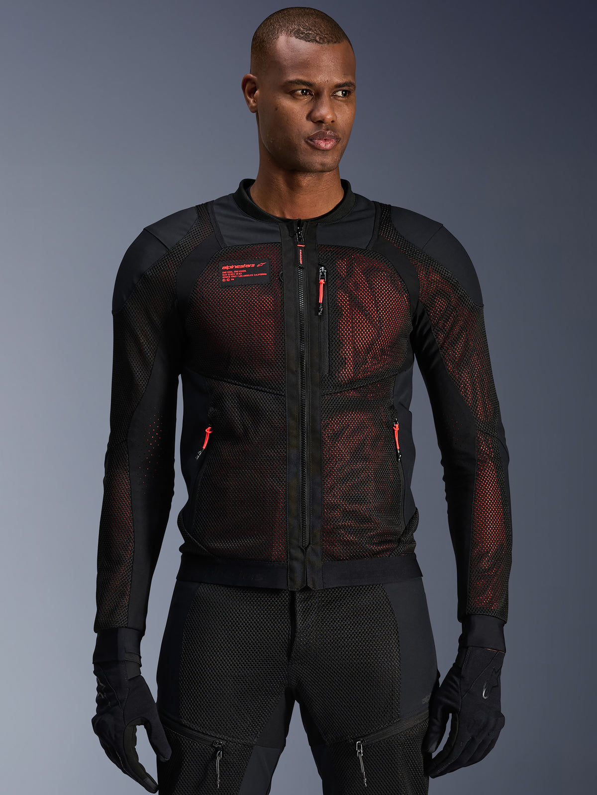 Alpinestars Troop-Air Pro Jacket, technical armored motorcycle jacket, Black and Red Fluo, featuring red zipper pulls and Alpinestars logo, breathable mesh panels with red underlay, worn with matching black riding pants and gloves