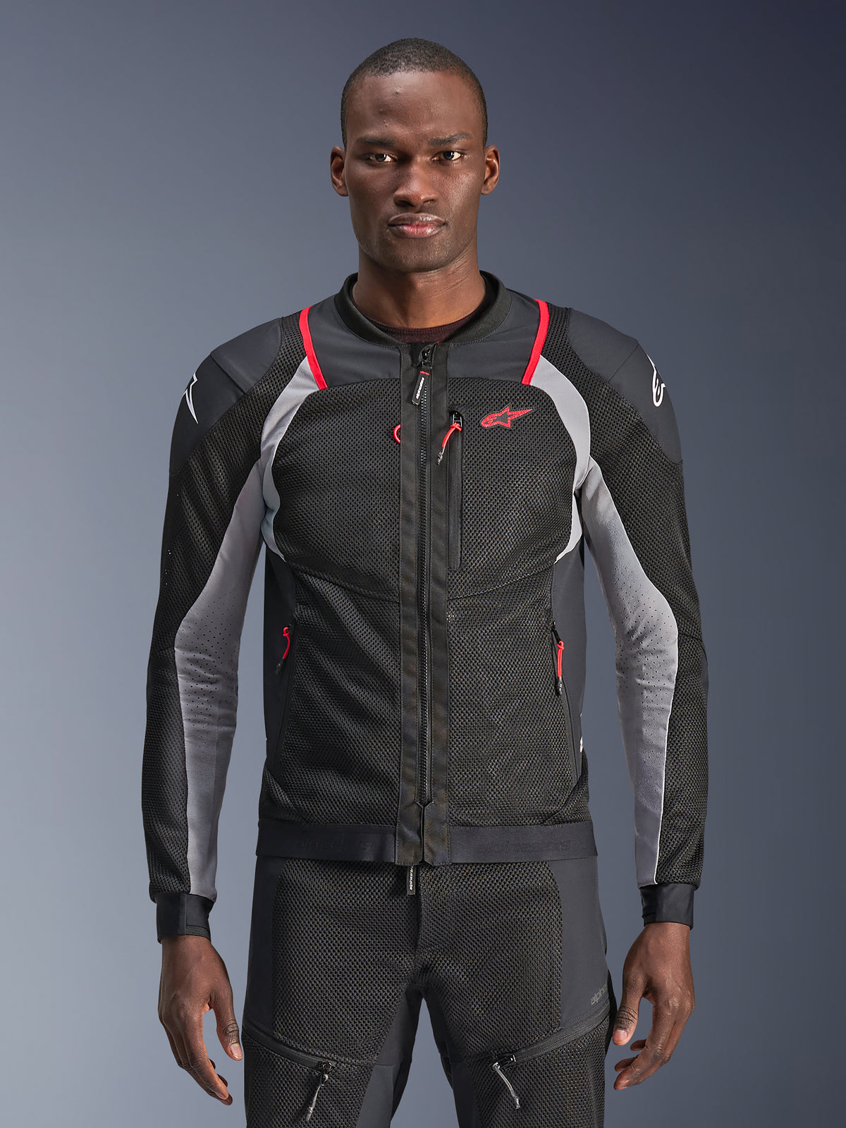 Alpinestars Troop-Air Pro Jacket, Black Ash Gray and Bright Red, worn by a model, motorcycle mesh jacket with perforated ventilation panels, featuring red zippered pockets and white shoulder logos, technical armored riding gear
