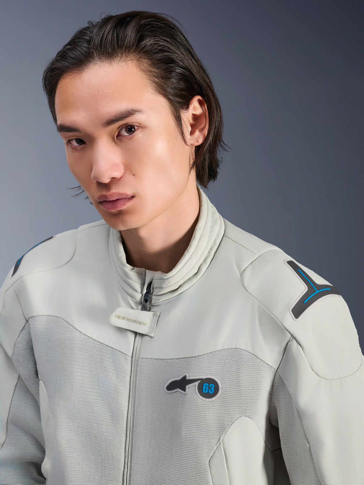 Chaqueta Alpinestars Circal-1 Air, gris metalizado con acentos en azul Methyl, modelo masculino vistiendo chaqueta de moto urbana de verano, primer plano de los paneles de malla de flujo de aire y marca minimalista en el pecho
