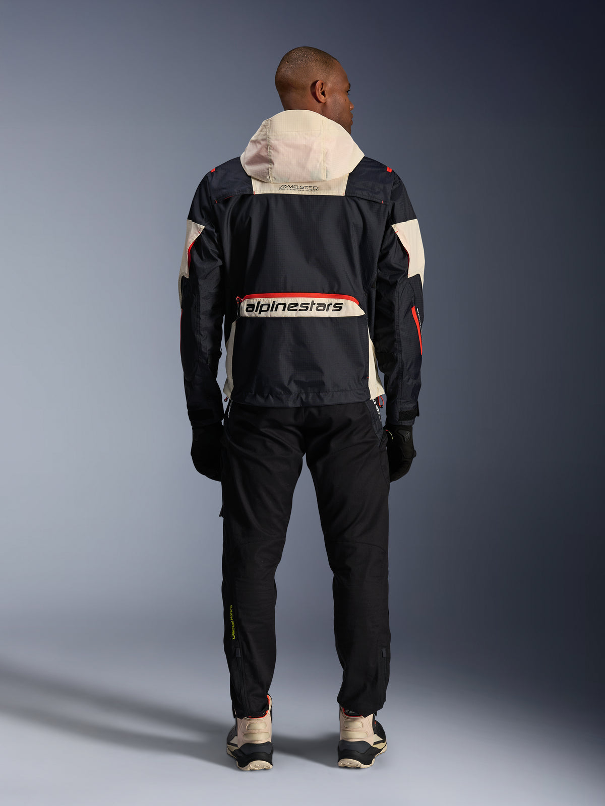 Alpinestars Mogress Air, vista trasera de chaqueta de moto urbana para hombre, negra y naranja con capucha crema