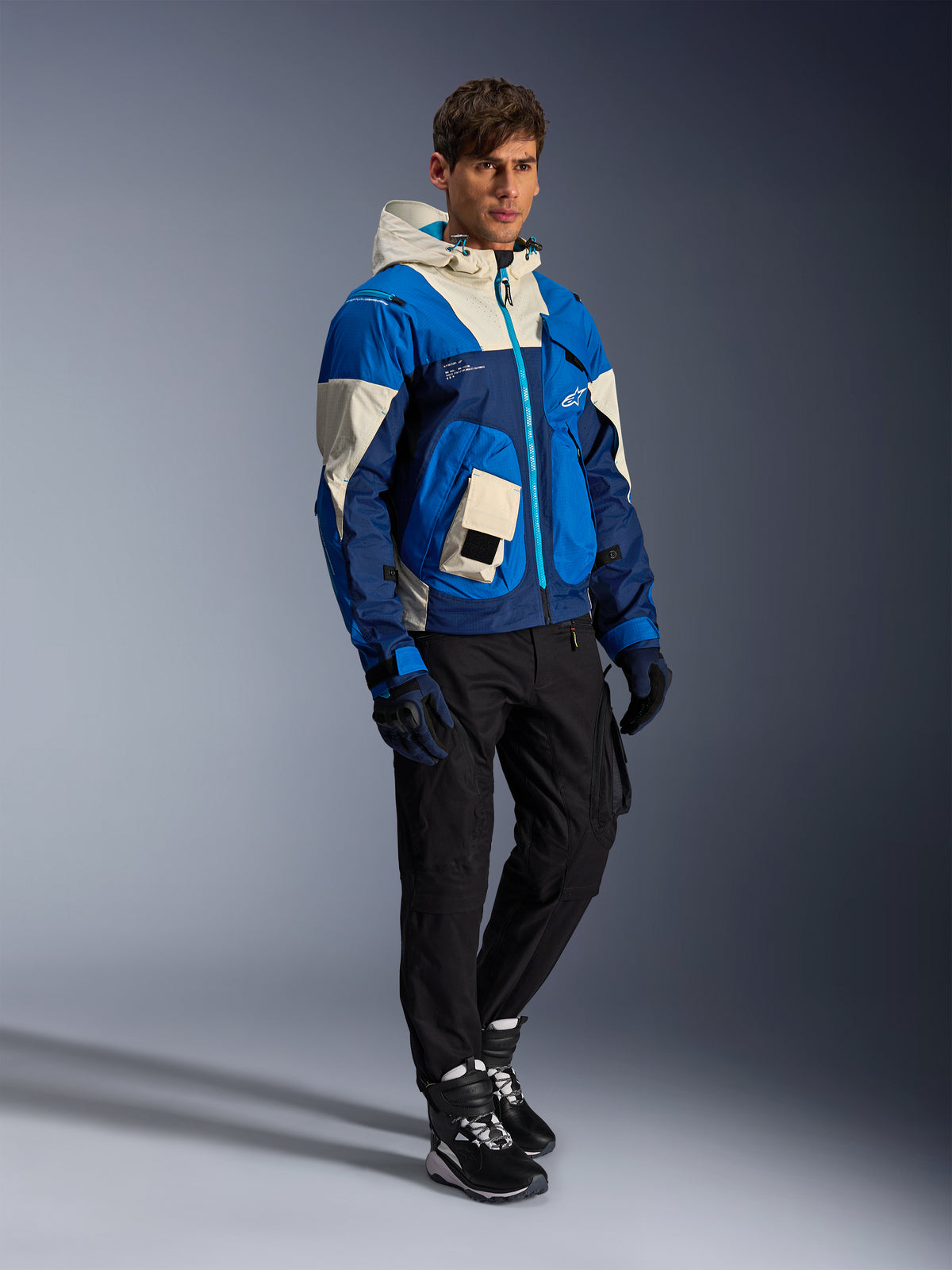 Chaqueta Alpinestars Mogress Air, de moto urbana para hombre, azul y crema, con capucha y bolsillos utilitarios.