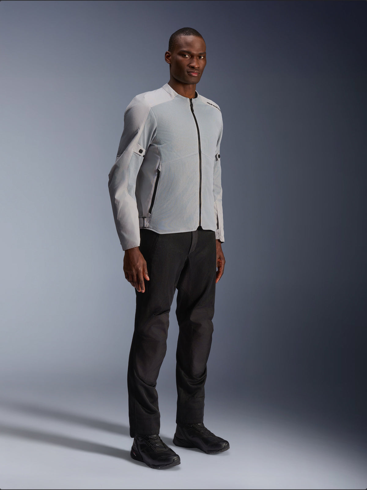 Chaqueta Alpinestars C-1 Air en plata y gris, chaqueta de moto urbana, construcción ligera de tejido técnico y malla, combinada con pantalones de moto negros y calzado negro, diseño limpio y contemporáneo para la conducción en ciudad