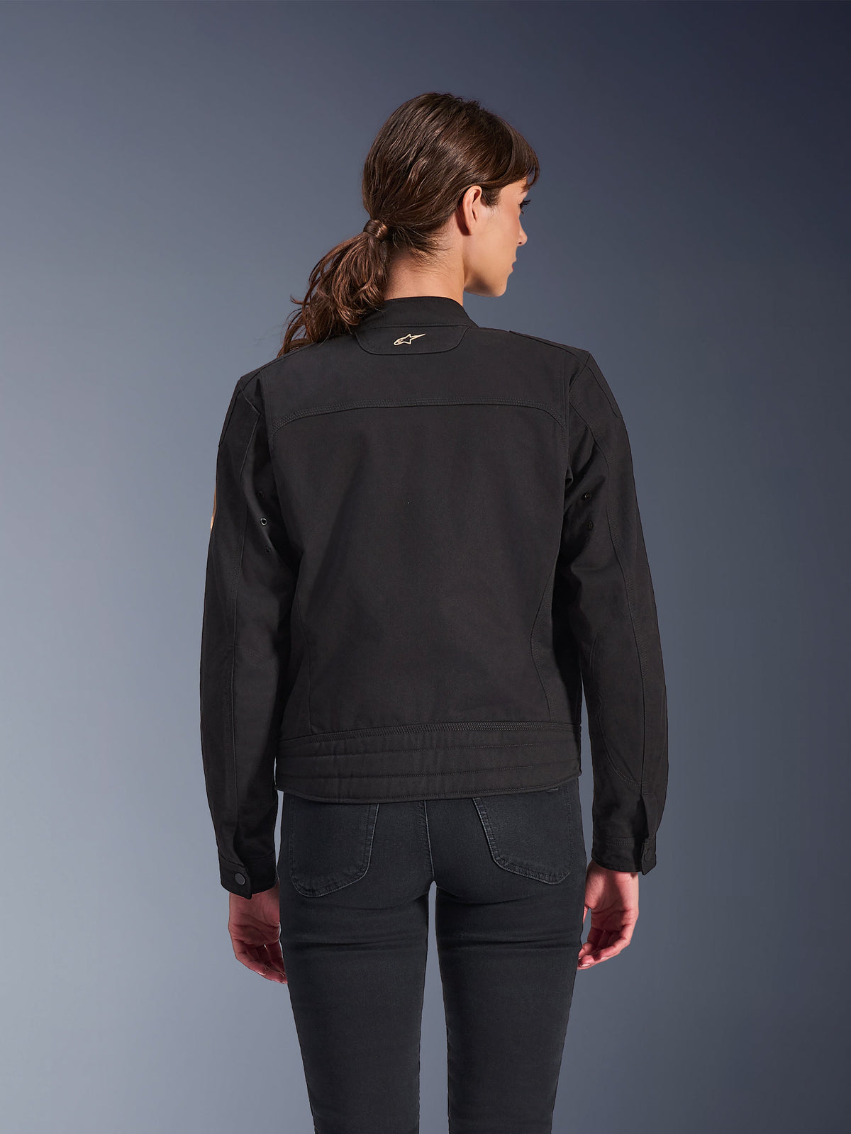 Chaqueta Alpinestars Woman Stella Grace, negra, vista posterior, chaqueta urbana para moto con estética clásica de ropa de trabajo, confección en tejido de sarga de policotón, combinada con pantalones vaqueros negros