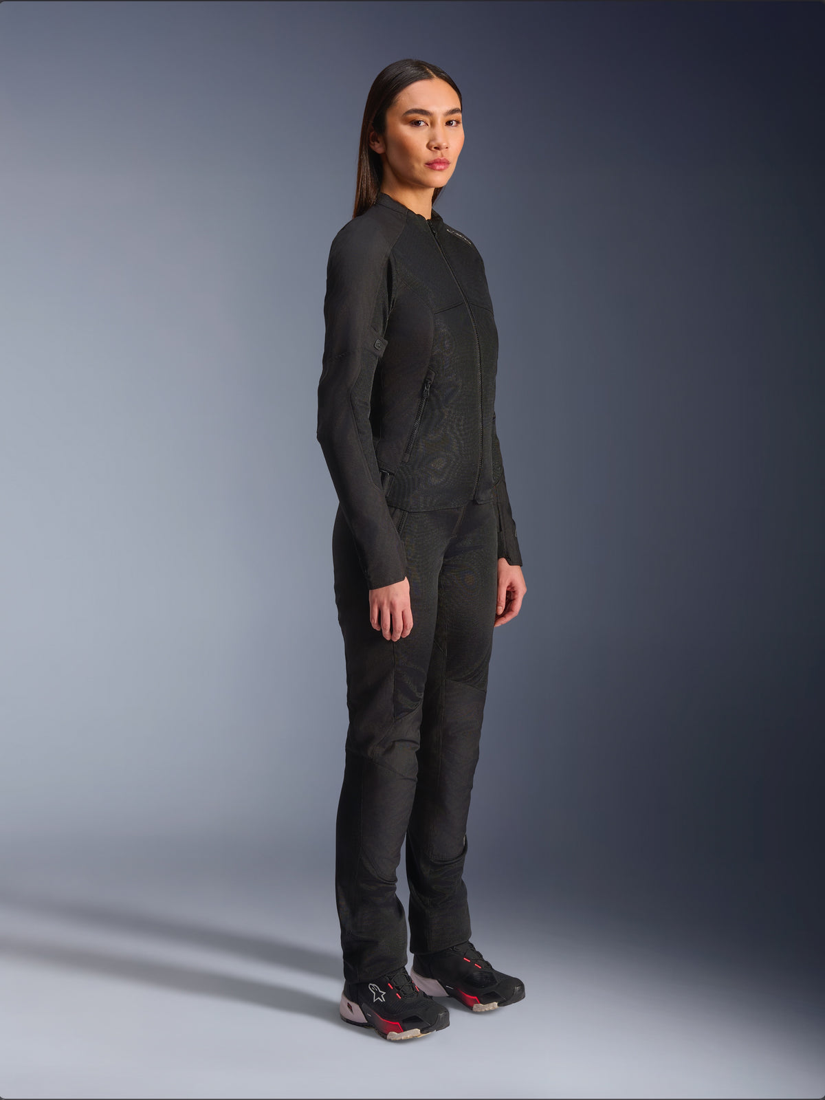 Chaqueta Alpinestars Stella C-1 Air para mujer en color negro, chaqueta textil de moto con paneles de malla, combinada con pantalones de conducción negros a juego y zapatillas técnicas, foto de estudio que muestra un conjunto completo de equipamiento para conducción urbana.