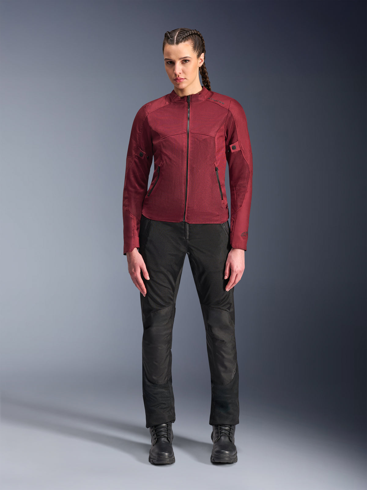 Alpinestars Woman Stella C-1 Air Jacket, Burgundy textile motorcycle jacket, featuring mesh panels for ventilation and zippered pockets, worn by model with black riding pants and boots, urban contemporary riding gear for women