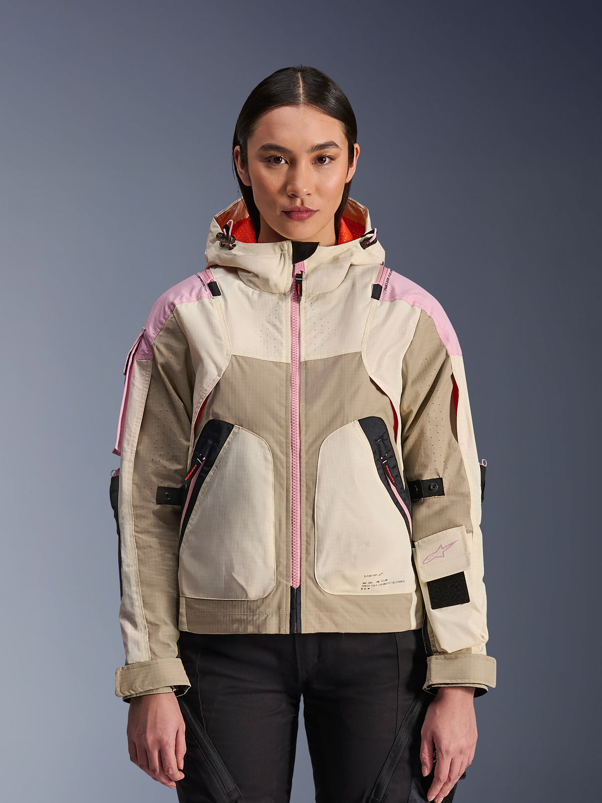 Alpinestars Molly Air Jacket, chaqueta urbana de motociclismo para mujer, en color Sand Pink Almond, con diseño de capucha, ventilación perforada por láser, detalle de cremallera rosa y correas ajustables en las mangas, mostrada en una modelo.