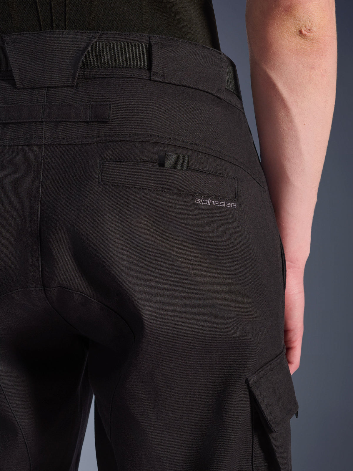 Primer plano de los pantalones cargo Alpinestars Flex-AST en color negro, pantalones urbanos de moto con un bolsillo trasero detallado y marca sutil, trabillas grandes para el cinturón y un bolsillo cargo lateral en tejido elástico resistente