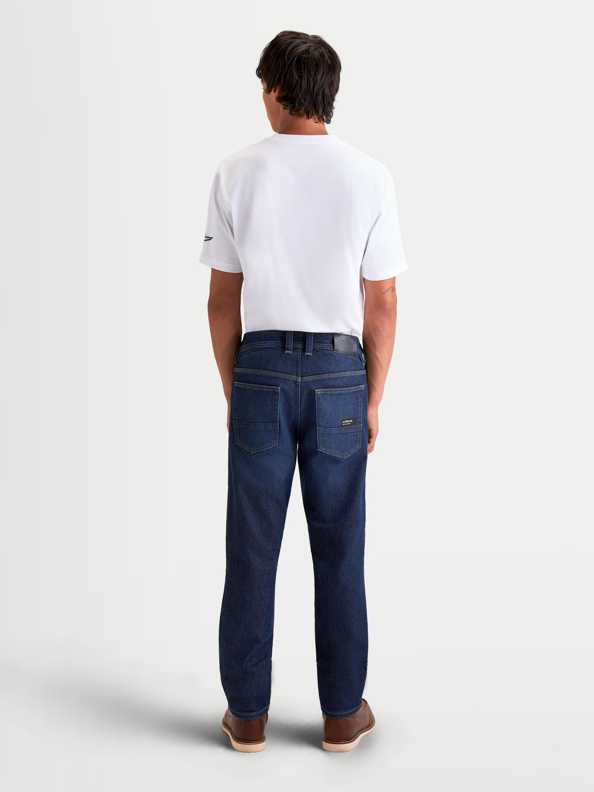 Alpinestars Flex-AST 7 Denim Pants, men's urban motorcycle riding jeans in dark blue, rear view showing single-layer technical denim construction, leather back patch, and embroidered Astar pocket detail worn on a model