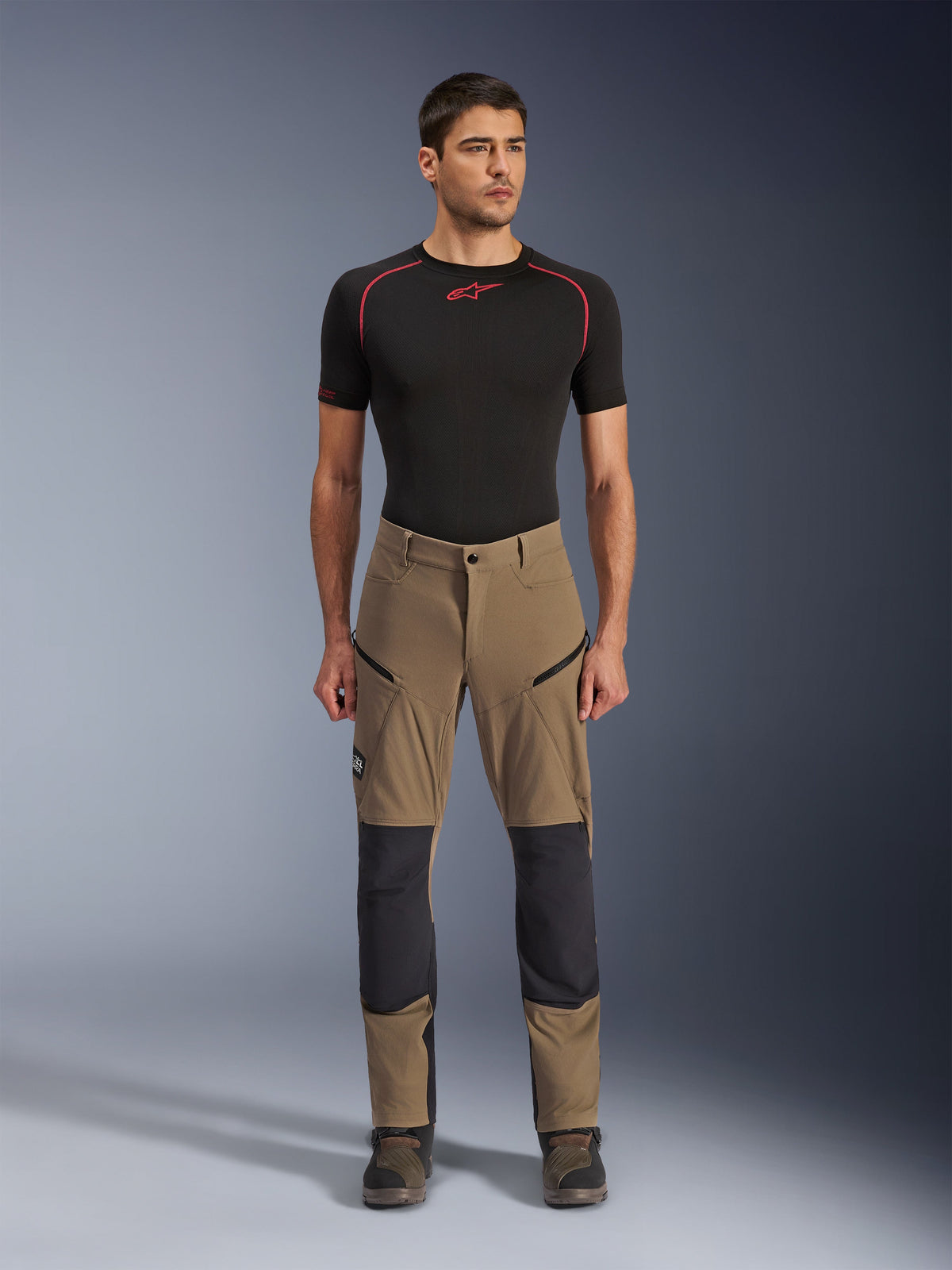 Alpinestars Flex-AST Explorer Pants, Motorcycle Touring Pants, Walnut Brown and Black, featuring reinforced knee panels and zippered thigh pockets, worn with black short-sleeve base layer, full body view