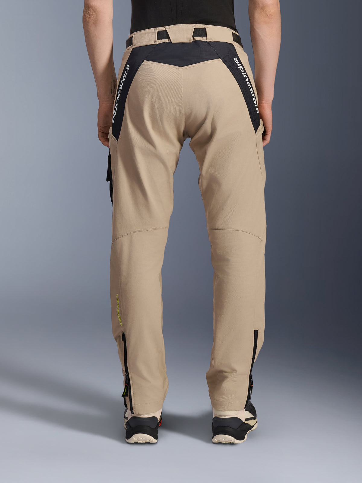 Pantalones Alpinestars Acteon, pantalones de moto urbanos, color Arena, vista trasera con paneles ripstop negros y marca en blanco en el canesú, corte entallado con cremalleras en la parte inferior de la pierna, equipamiento moderno para conducción en carretera