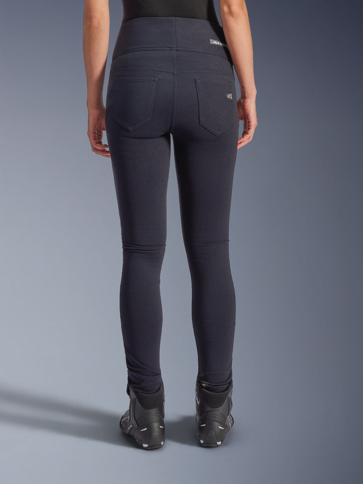 Alpinestars Stella Flex-AST Leggings, pantalones urbanos para moto, negros, vista trasera con ajuste entallado de talle alto, dos bolsillos traseros funcionales con marca sutil, material textil elástico, usados con calzado de conducción negro