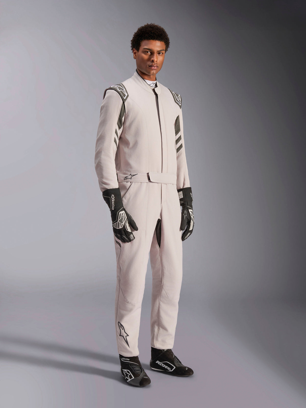 Alpinestars GP Race V3 Suit FIA, traje de carreras Silver Anthracite, mono de piloto de una pieza con hombreras y cintura con cinturón, usado con guantes y botas de carreras a juego en blanco y negro, diseño elegante para automovilismo profesional