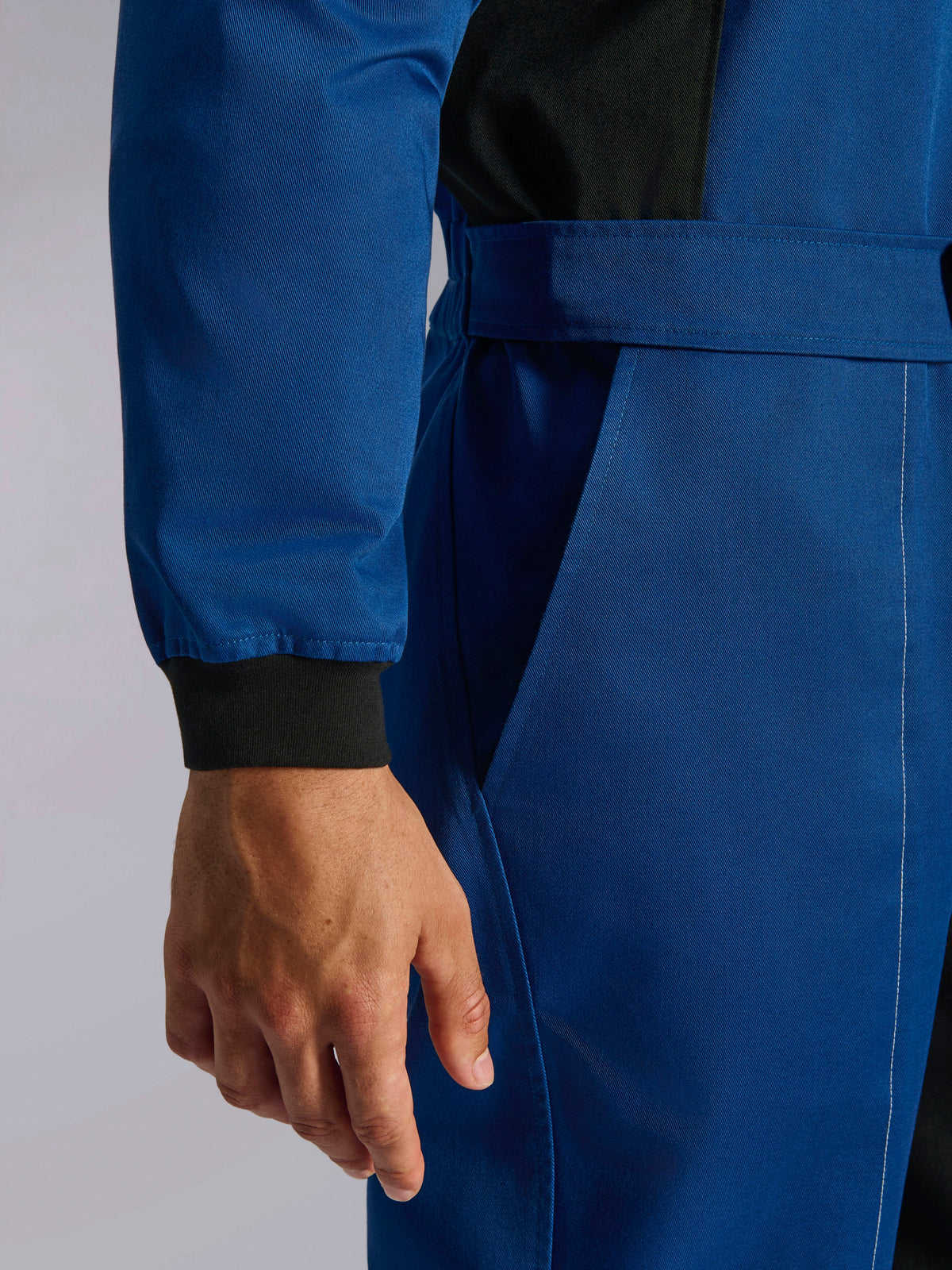 Alpinestars Kart Indoor V2 Suit, Blue karting suit, close-up detail of the adjustable waist belt and knitted wrist cuff, durable poly-cotton twill fabric with black accents and functional pocket