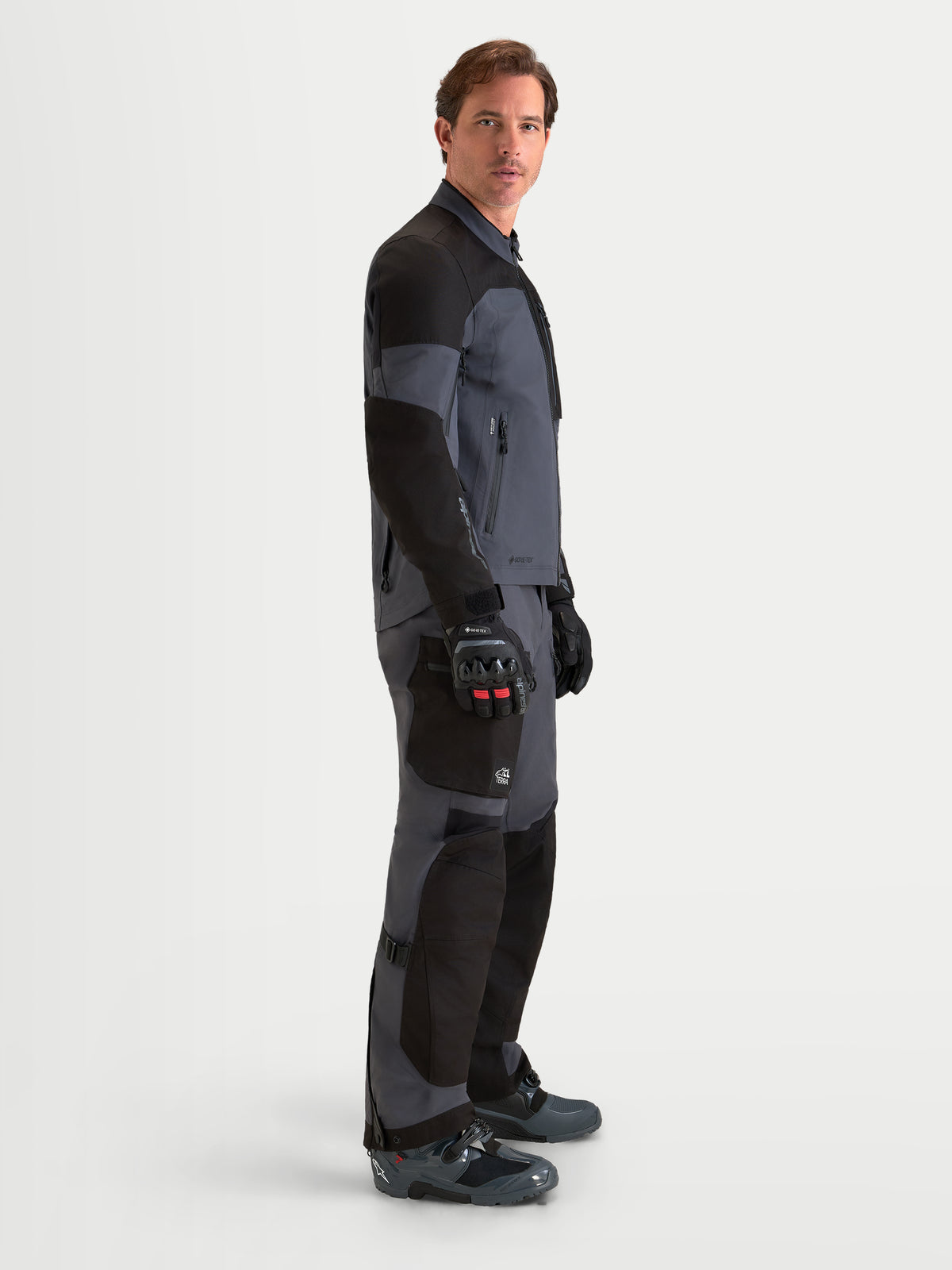 Alpinestars Arenis Gore-Tex Chaqueta, chaqueta de moto de aventura para hombre en negro y gris oscuro, vista de perfil lateral que muestra la construcción textil impermeable y el cuello ergonómico en modelo