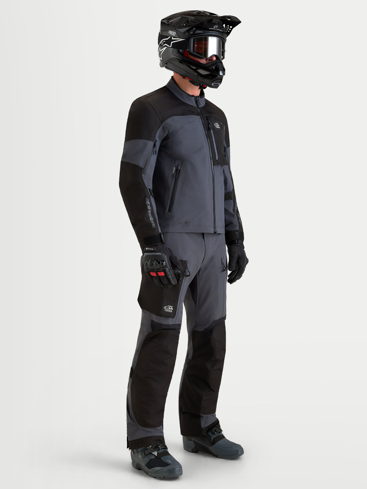 Alpinestars Arenis Gore-Tex chaqueta, chaqueta de moto de aventura para hombre en negro y gris oscuro, vista de perfil lateral que muestra construcción textil impermeable, cuello ergonómico y equipo de protección en modelo