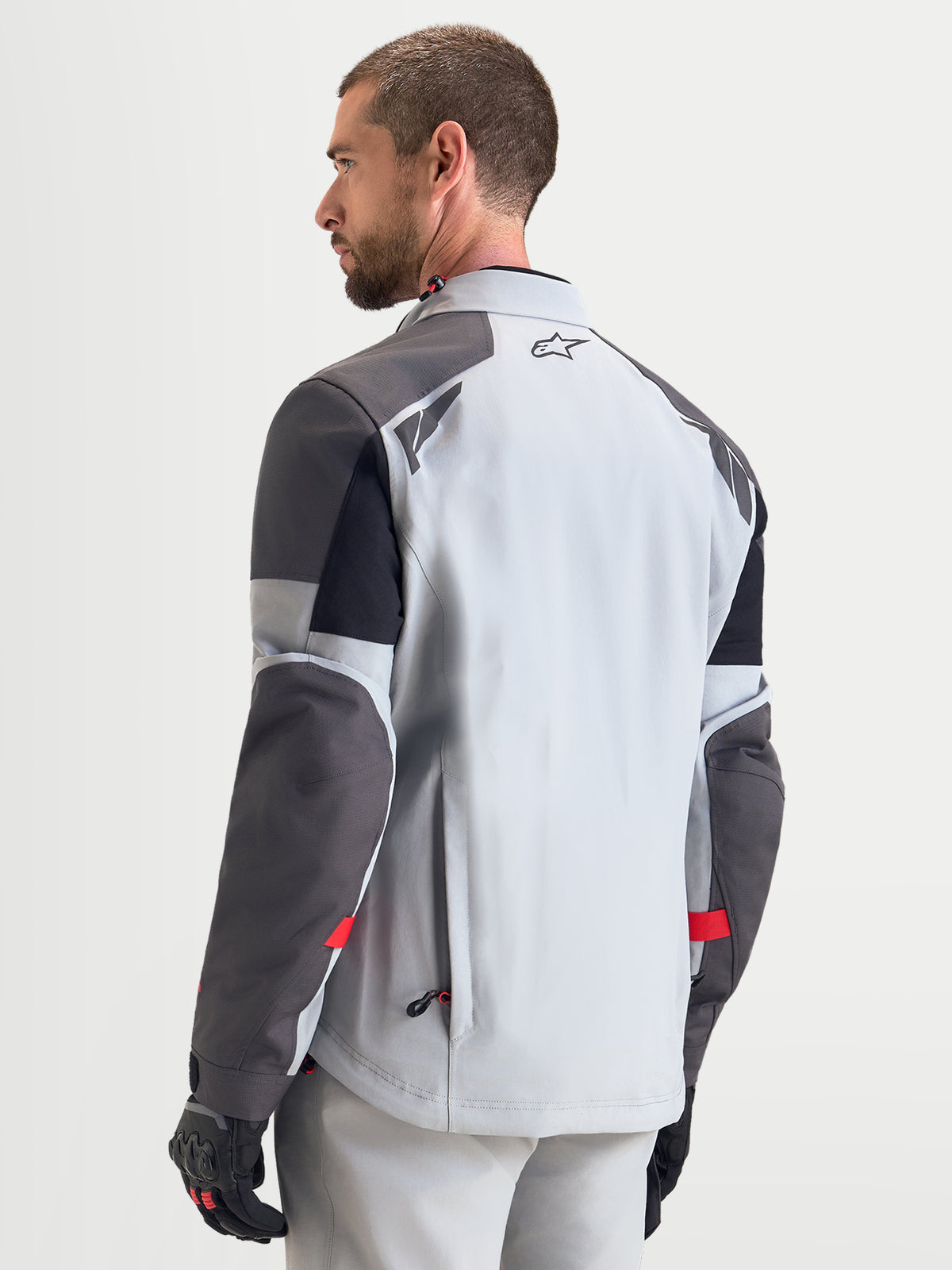Chaqueta Alpinestars Arenis Gore-Tex para hombre, chaqueta de moto de aventura en gris medio, gris oscuro y negro, vista trasera que muestra la construcción textil impermeable y detalles reflectantes en los hombros en modelo