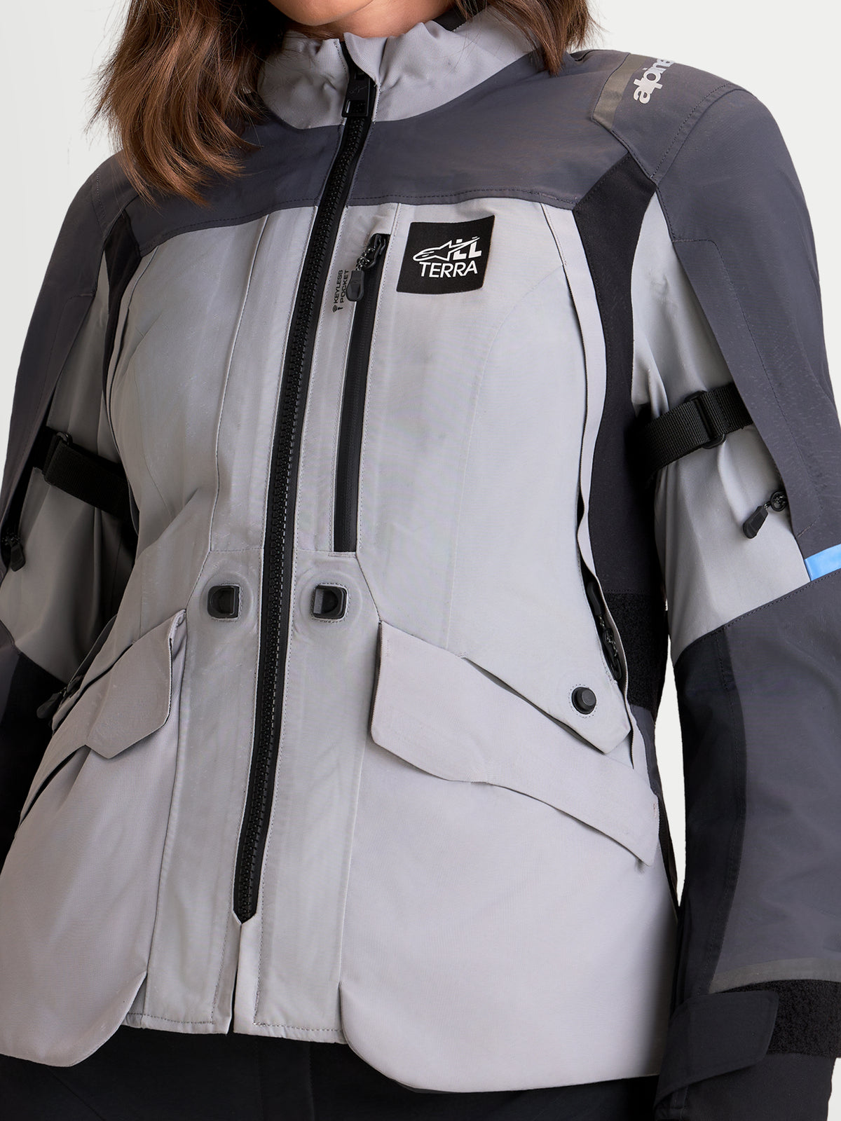 Alpinestars Stella ST-7 V2 2L GORE-TEX, chaqueta de moto de aventura para mujer en gris medio, gris oscuro y negro, vista de cerca con construcción textil impermeable, bolsillos delanteros y logotipo All Terra en modelo