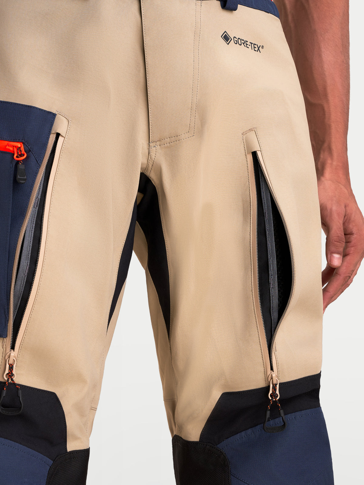 Alpinestars Arenis Gore-Tex Pants, adventure touring motorcycle pants, beige, navy, and black, close-up view showing thigh ventilation zippered openings and Gore-Tex branding