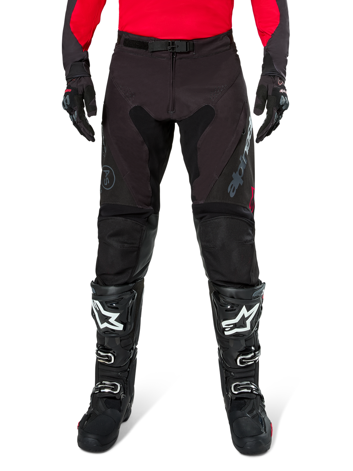 Pantalones Alpinestars Pro-Dura, pantalones de enduro en color negro y magnet, combinados con un jersey rojo de manga larga y botas de motocross negras, con logotipos grises de Alpinestars y una construcción de ripstop resistente para conducción off-road.