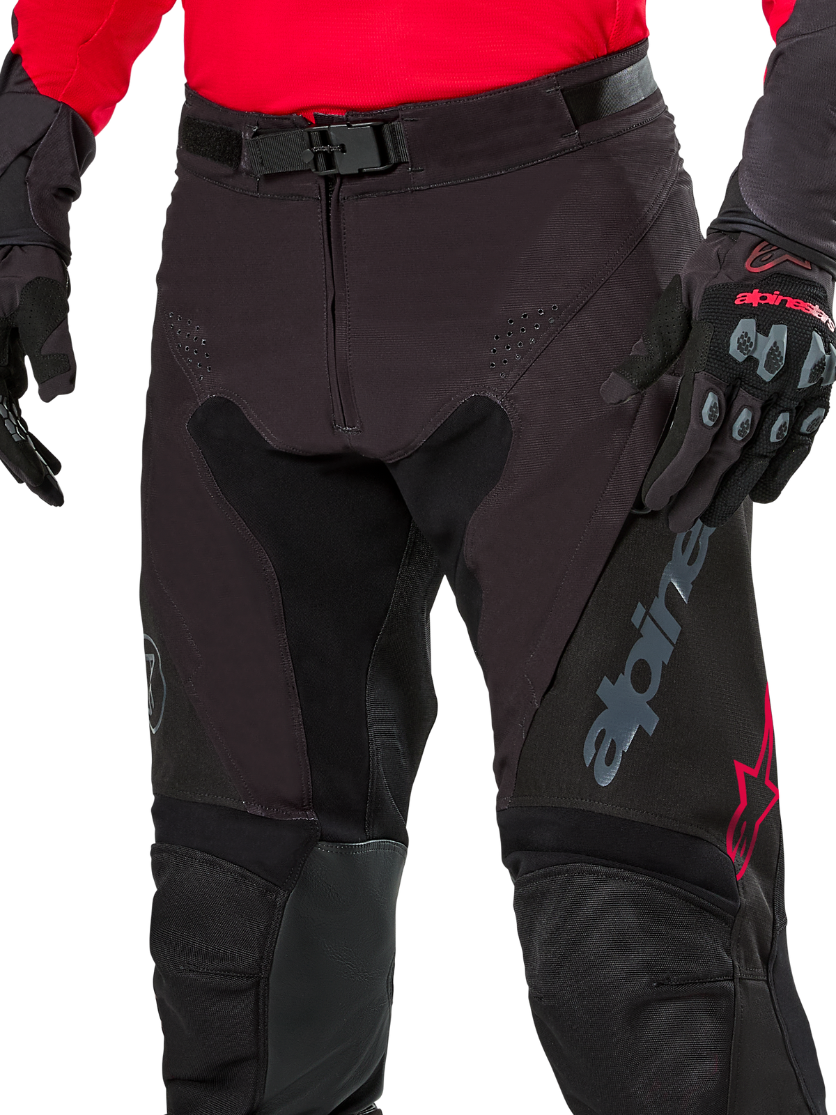 Alpinestars Pro-Dura Pants, pantalones de enduro, color negro magnet white con detalles rojos, cierre de hebilla magnética y bragueta con cremallera, usados con jersey rojo y guantes negros, construcción de ripstop duradera para conducción off-road