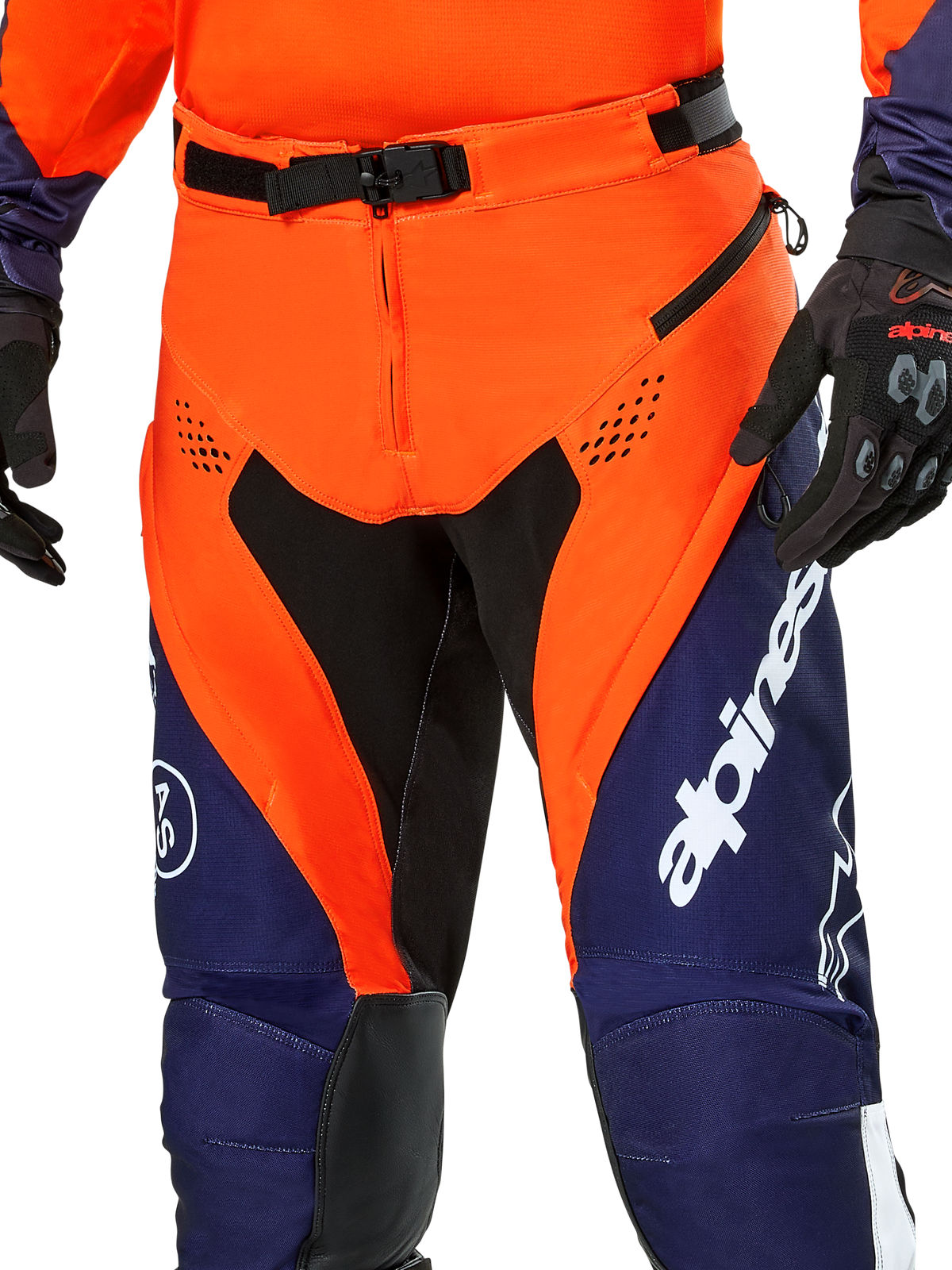 Alpinestars Pro-Dura Pants, pantalones de enduro para motociclismo, azul navy, naranja vibrante y blanco, vista detallada de la cintura con hebilla magnética SX2 y ventilaciones con cremallera en los muslos, material ripstop duradero con logotipos llamativos, usados con equipamiento a juego