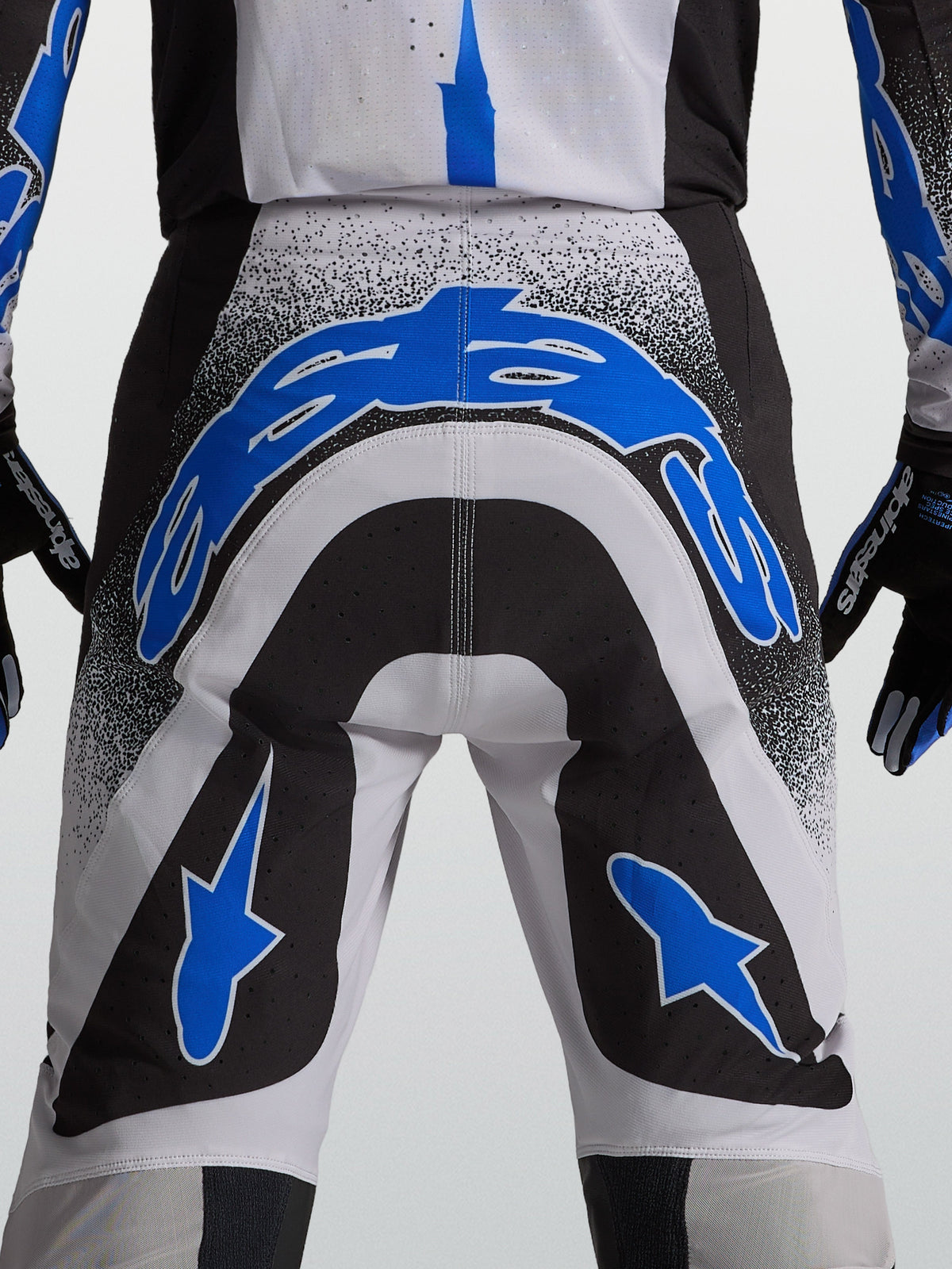 Pantalones Alpinestars Supertech Hiten AFD de motocross para hombre, color azul, blanco y negro, con ajuste atlético y paneles elásticos técnicos, vista posterior.
