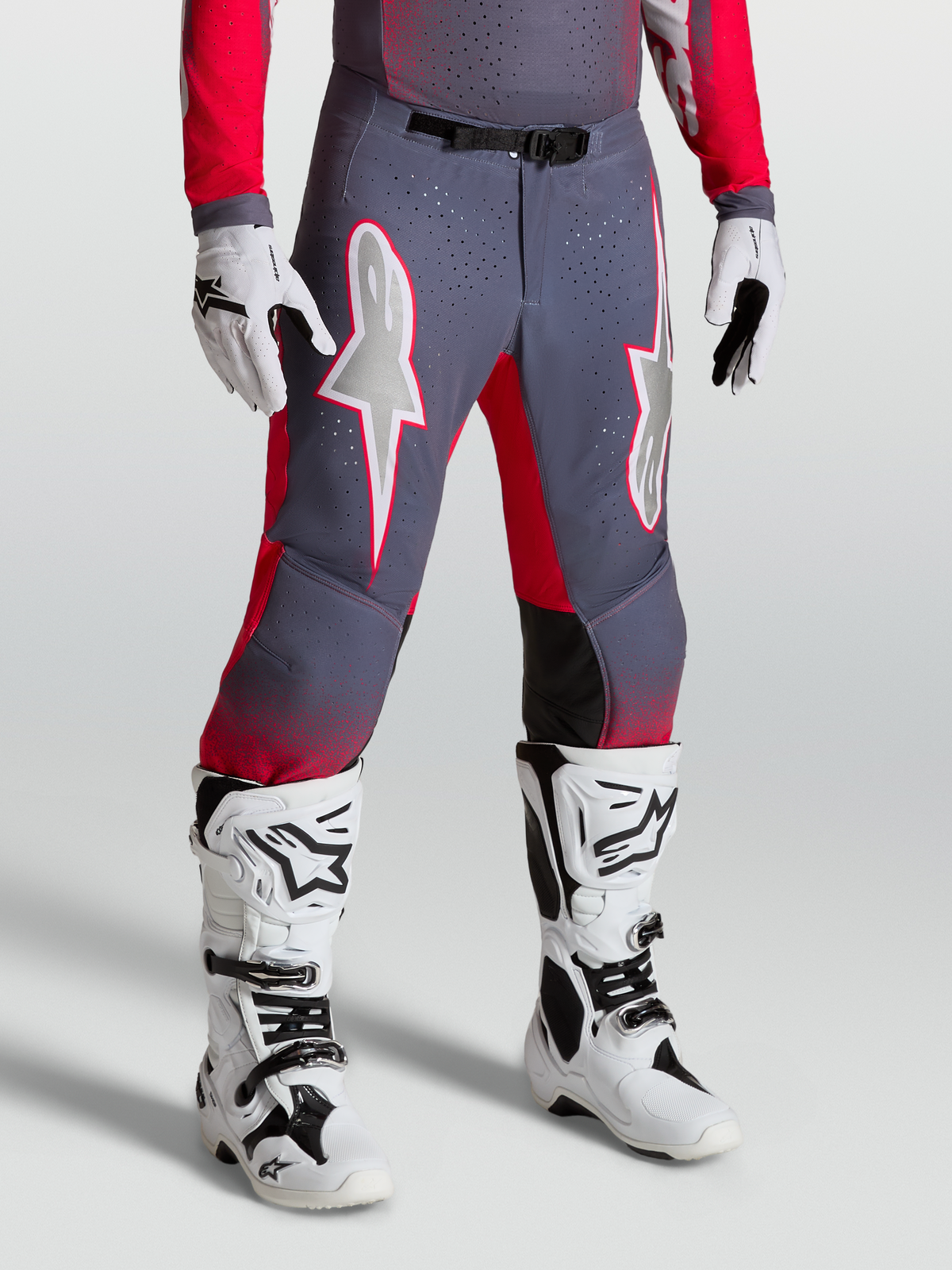 Alpinestars Supertech Hiten AFD, pantalones de motocross para hombre, grises y rojos, con gráficos de estrella y hebilla magnética, usados con botas blancas