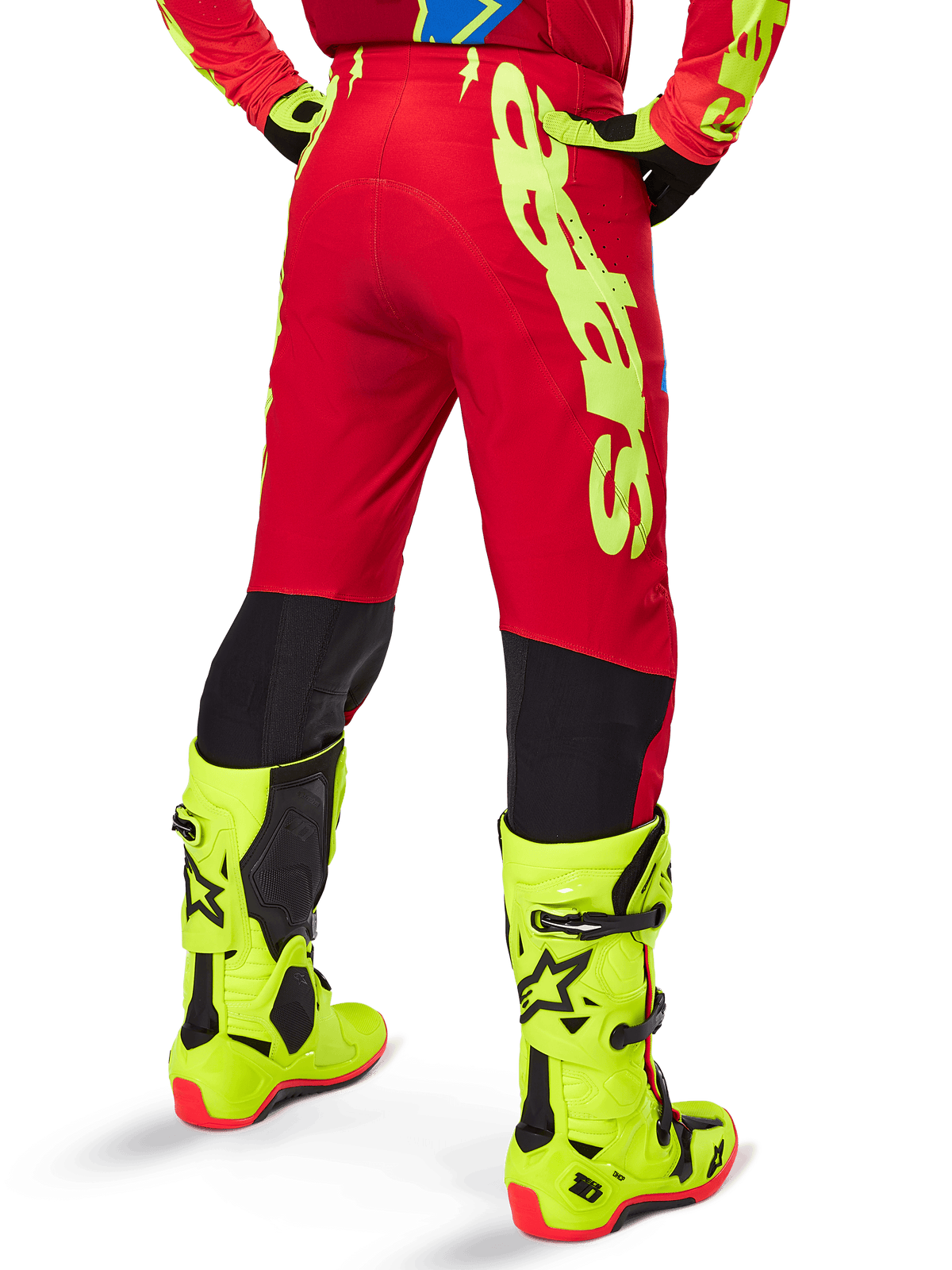 Alpinestars 2025 Supertech Maker Pants, pantalones de motocross, rojo brillante y amarillo flúor, vista trasera, con marca llamativa en amarillo, paneles negros detrás de las rodillas, combinados con botas amarillo flúor a juego, diseñados para un rendimiento off-road de nivel profesional.